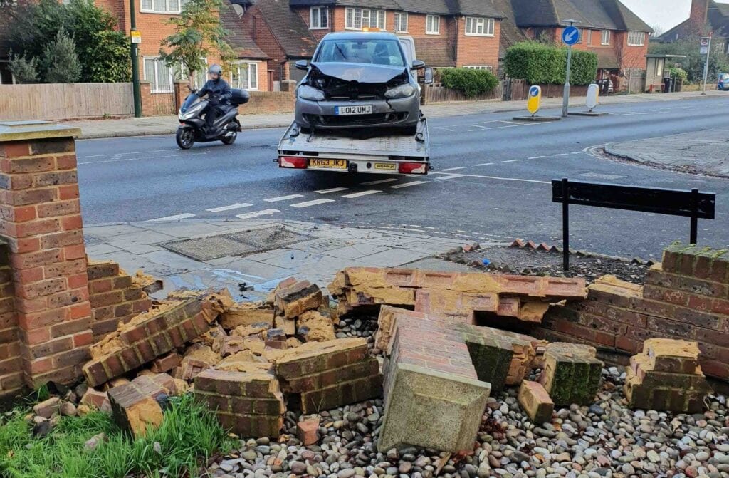 Accident towing service London — damaged car recovered on flatbed tow truck after crash