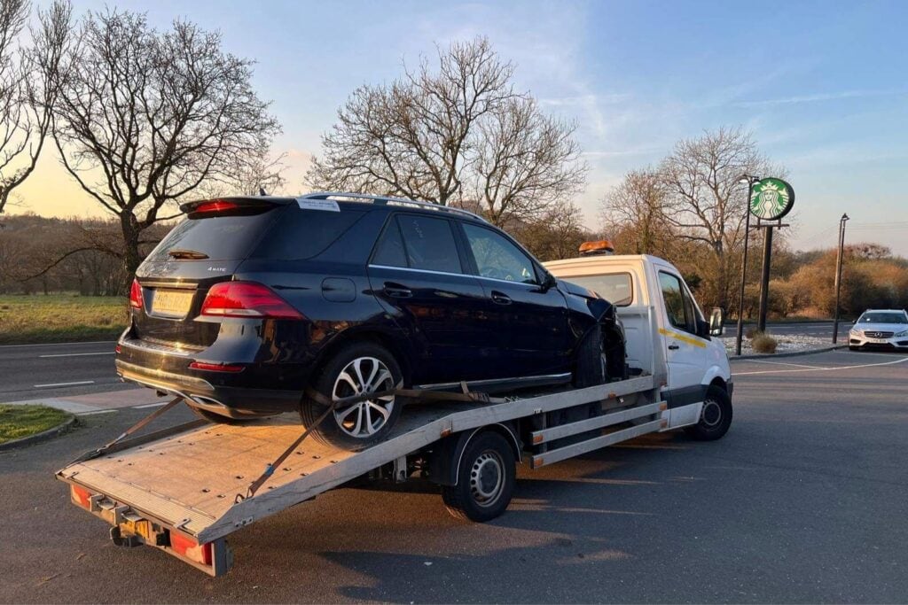 Flatbed tow truck in London recovering a black Mercedes after a breakdown