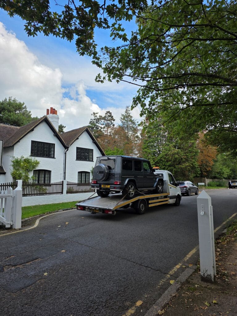 Flatbed tow truck loading a Mercedes G-Wagon on a quiet Surbiton street — London Auto Towing