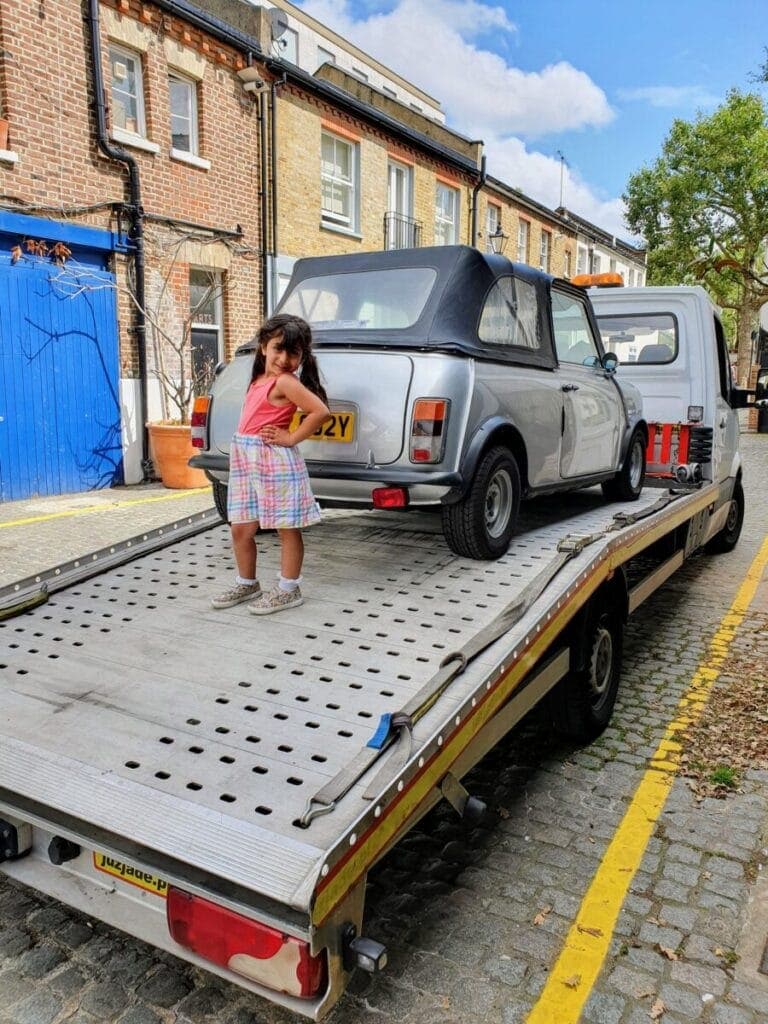 Flatbed recovery truck collecting a Mini from a family driveway in London