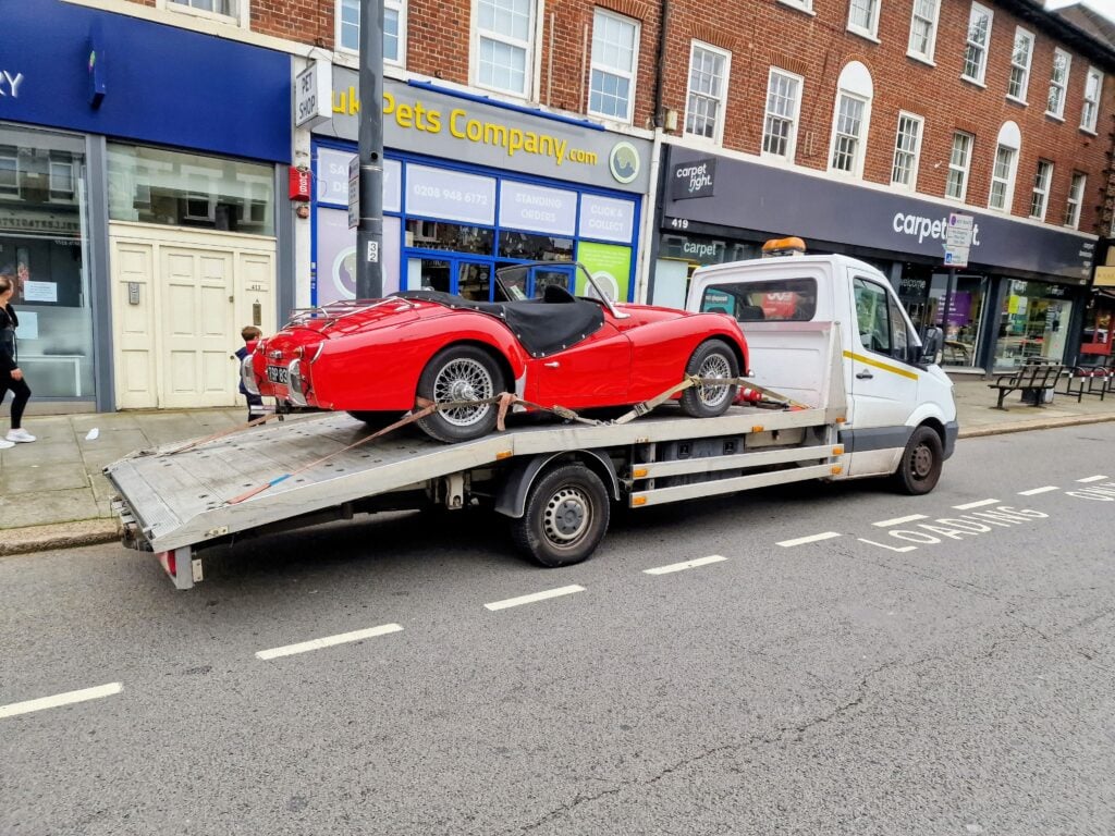 Red classic sports car on flatbed tow truck – London Auto Towing car recovery and towing service