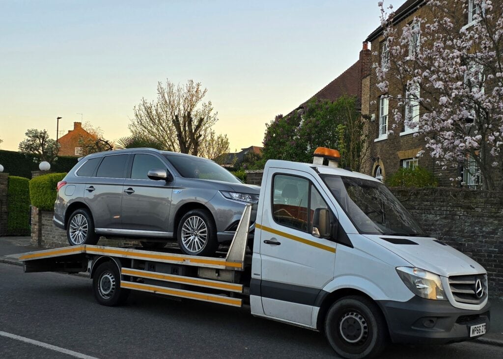 Emergency breakdown recovery service in London — London Auto Towing loading a silver Mitsubishi Outlander PHEV on flatbed tow truck.