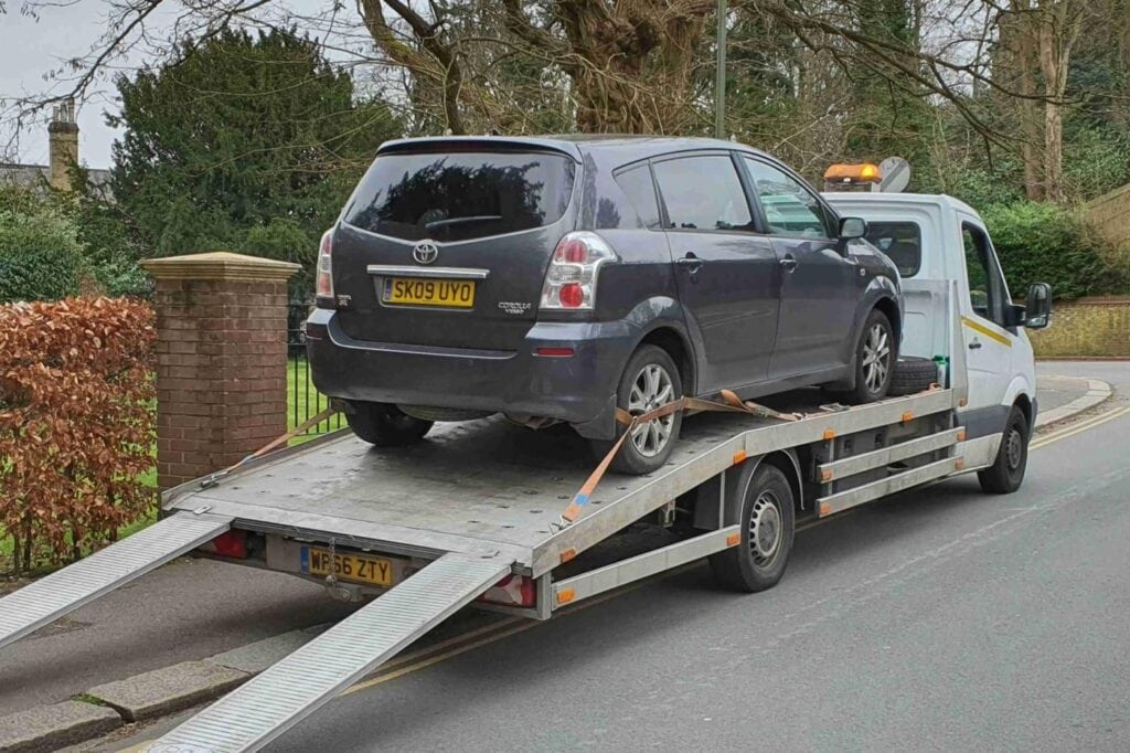 24 hour flatbed towing service London — Toyota Corolla Verso loaded on a flatbed recovery truck.