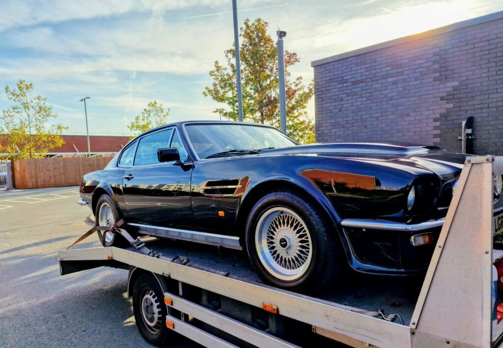 Classic Aston Martin on flatbed tow truck — high value car recovery London.