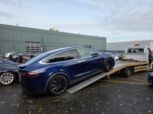 Blue Tesla Model X being recovered on our flatbed recovery truck during a low suspension electric car recovery job in London.