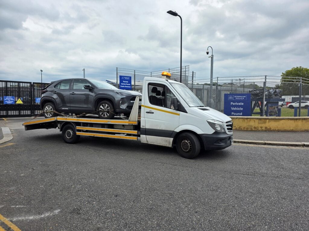police compound recovery London — vehicle collected by flatbed recovery truck from Metropolitan Police pound