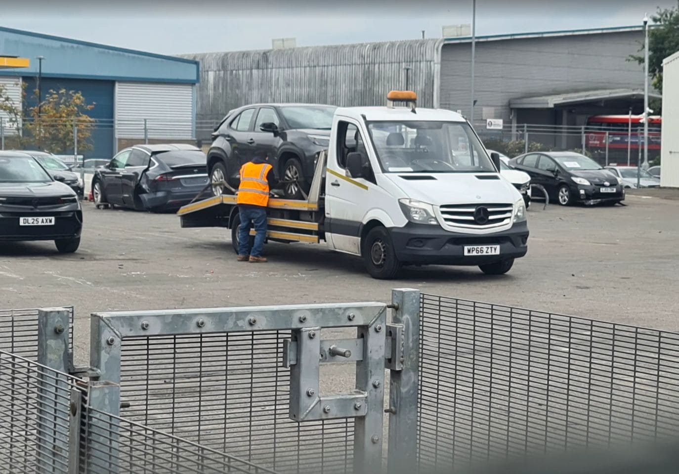 Police compound recovery London — Toyota Yaris Hybrid on flatbed tow truck by London Auto Towing.