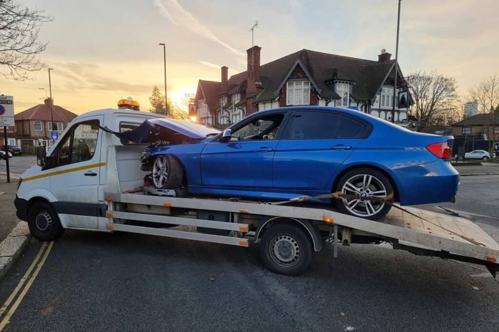 accident recovery London — damaged car loaded with wheel skates on flatbed towing service