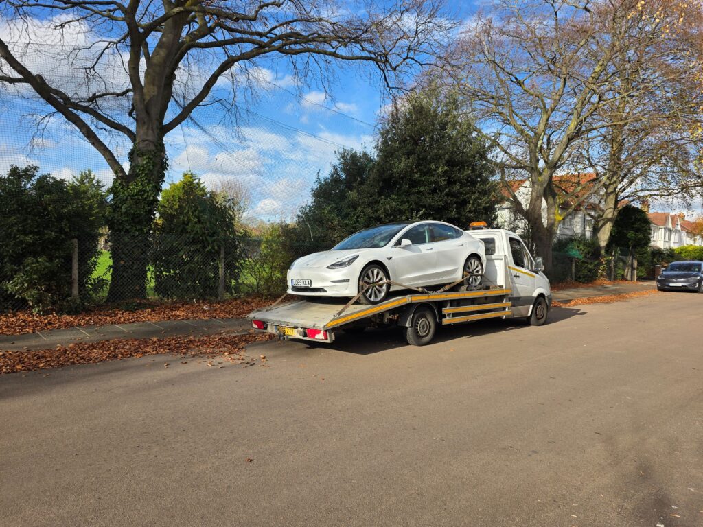 Electric car recovered on flatbed tow truck using wheel skates when tow mode failed