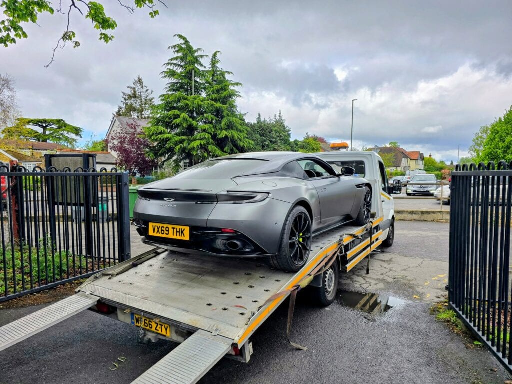 Aston Martin DB11 loaded on a flatbed tow truck for main dealer recovery in Surrey, secured for safe transport by London Auto Towing.