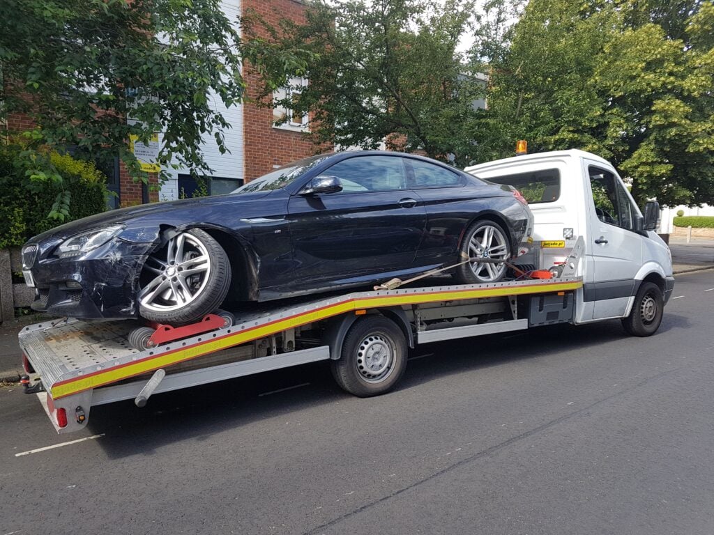 BMW 6 Series accident recovery on flatbed tow truck with wheel skates in London