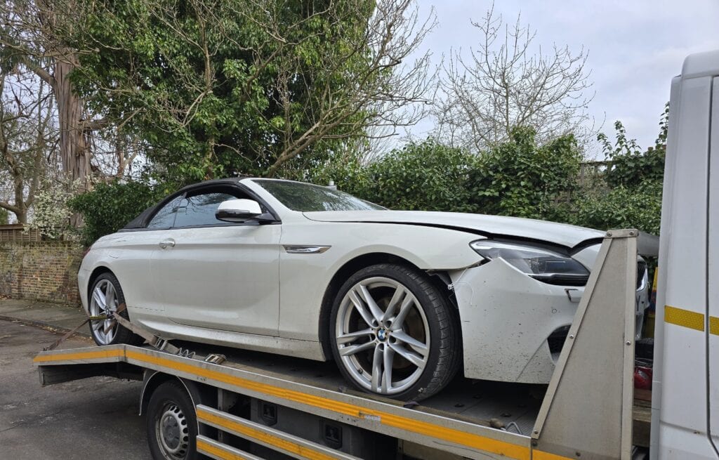 BMW 6 Series Convertible accident recovery secured on flatbed tow truck in London