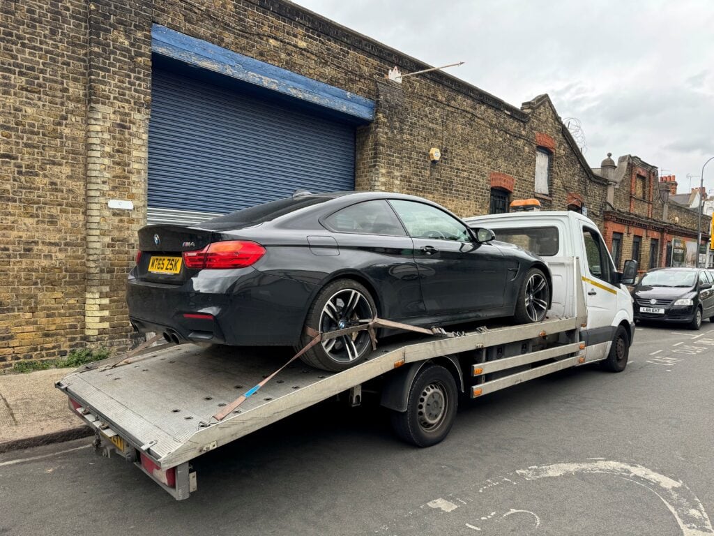 BMW M4 water flood recovery on flatbed tow truck with hydrolock risk in London