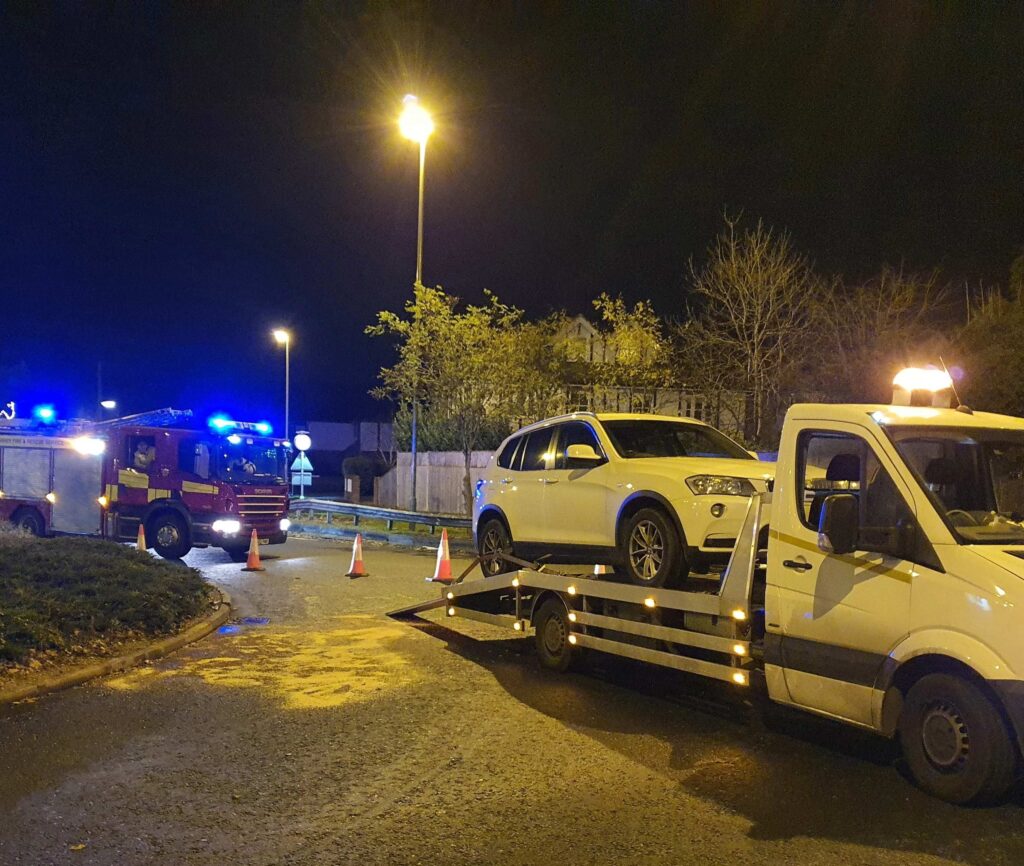 BMW X3 accident recovery at night secured on flatbed tow truck in London