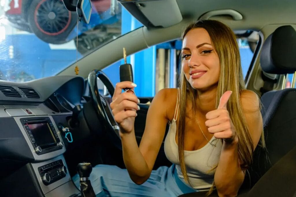 Customer holding car keys with thumbs up, confirming booking details for vehicle recovery support