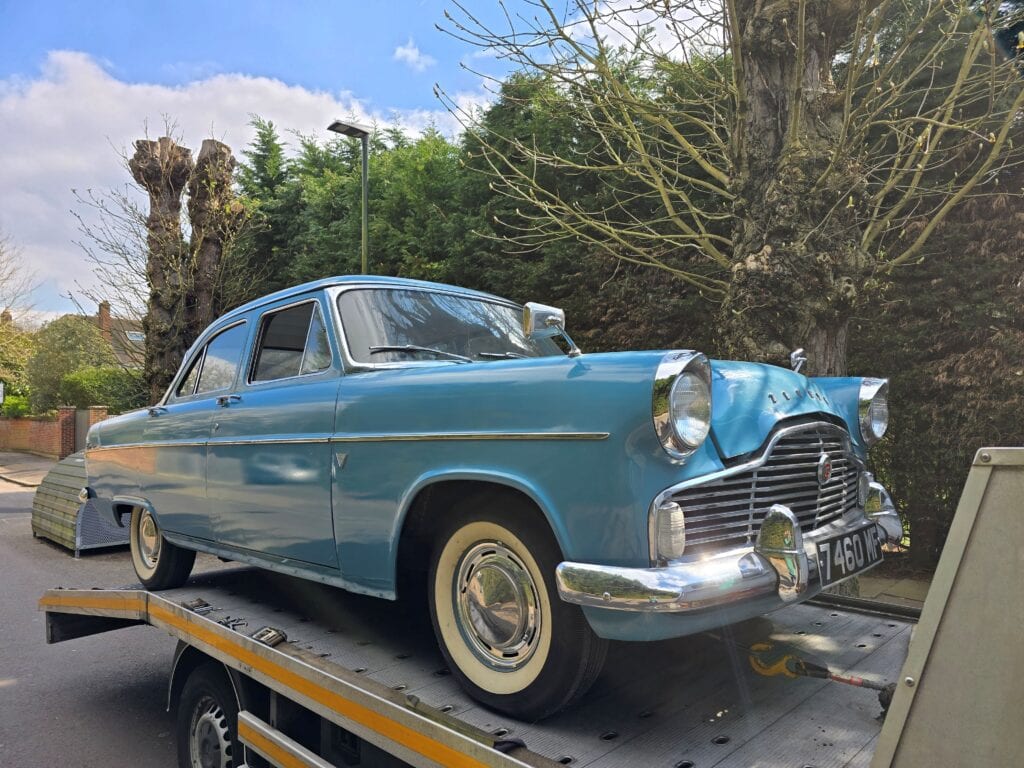 Classic car collected on a flatbed tow truck after sale to its new owner in London.
