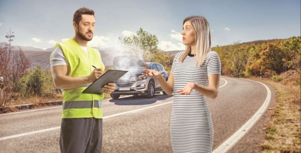 Roadside recovery operator taking details from a driver during a car recovery service