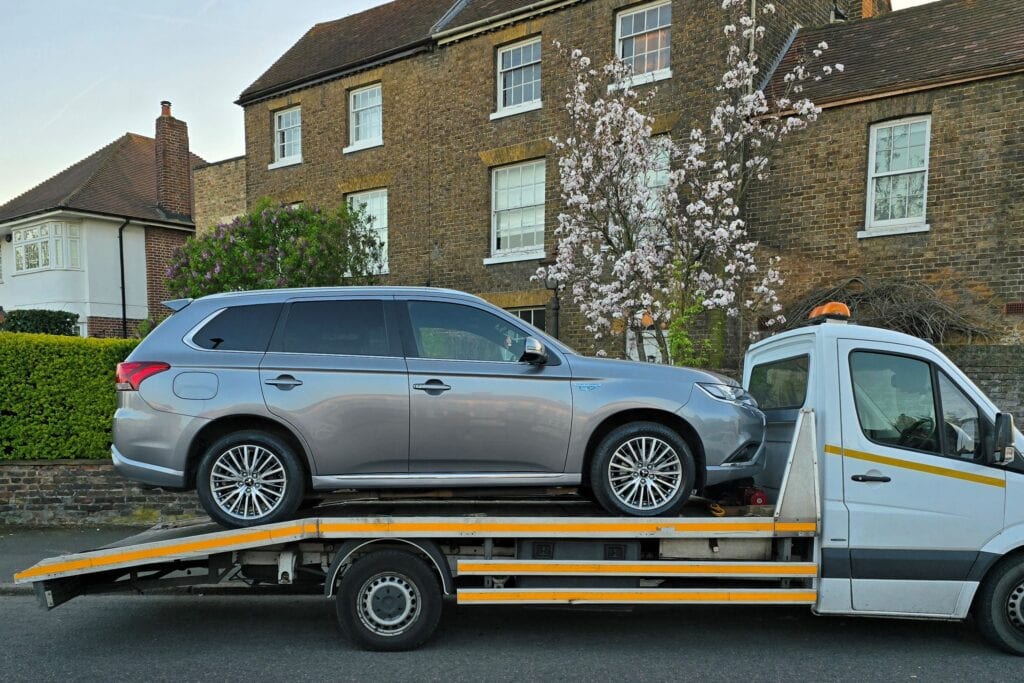 Hybrid family car loaded on our flatbed tow truck after being purchased as part of our we buy any cars service.