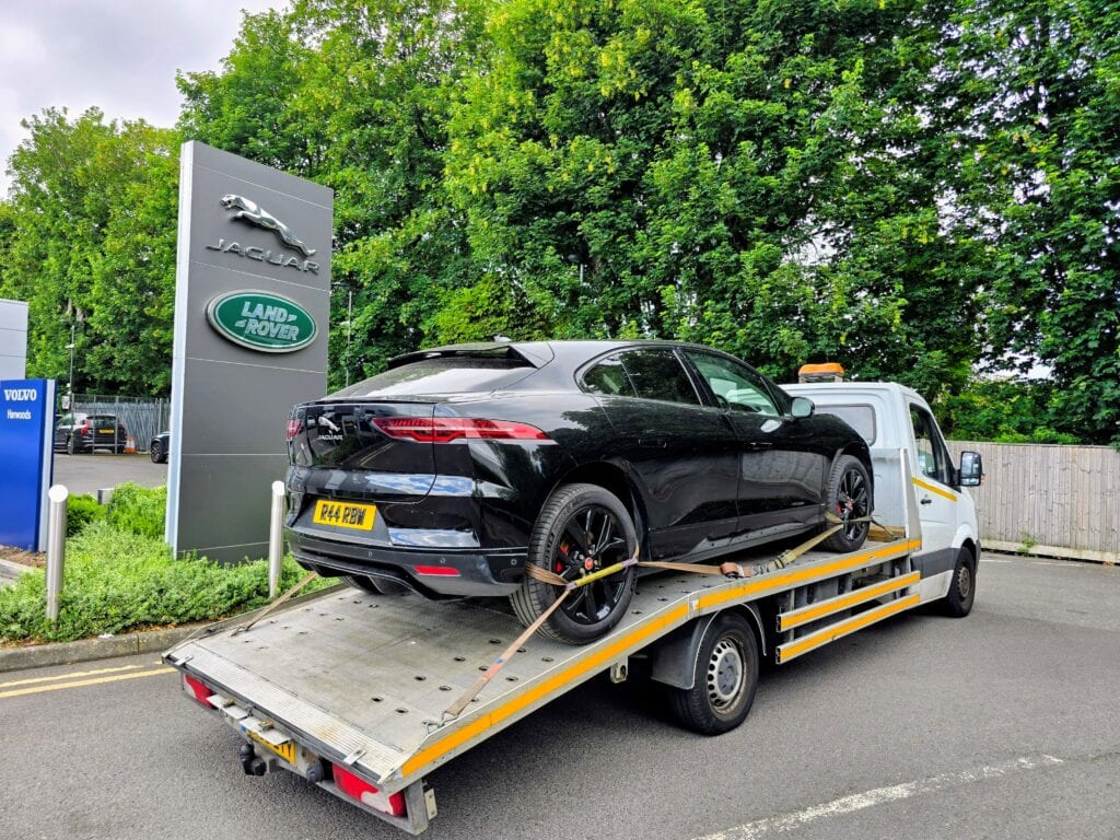 Jaguar I-PACE electric SUV recovered on a flatbed recovery truck after a high voltage battery issue and delivered to the main dealer in London