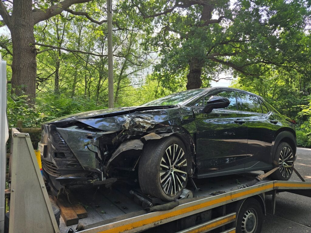 Damaged Lexus UX 300e electric SUV loaded onto a flatbed recovery truck after a collision in London.