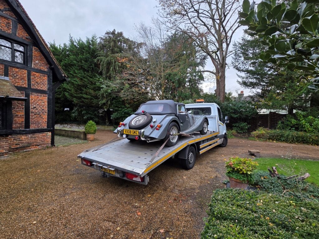 Classic car loaded on a flatbed tow truck during a London Auto Towing car recovery service.