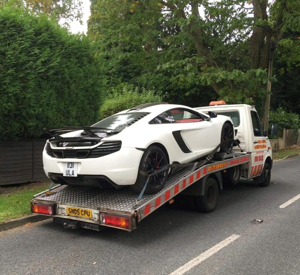 White McLaren 650S loaded onto a flatbed recovery truck, showcasing long-standing expertise in high value car recovery.