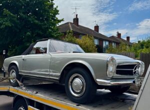 Classic Mercedes Benz Pagoda secured on our flatbed tow truck during high value car recovery in a London residential street.