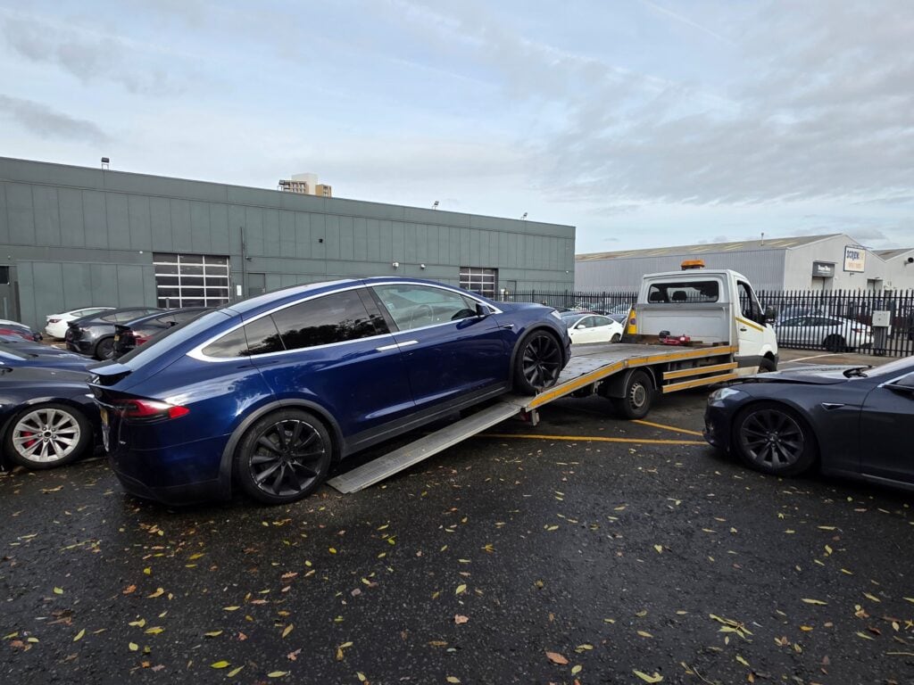 Tesla Model X electric SUV loaded onto a flatbed tow truck and delivered to Tesla Park Royal in London