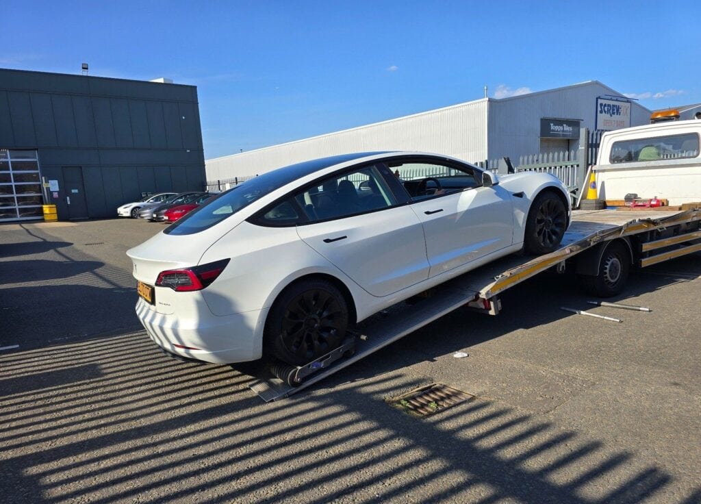 Tesla recovered with a parking brake fault, loaded using wheel skates and secured for safe transport in London.