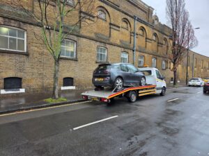 BMW i3 electric vehicle loaded onto flatbed recovery truck during breakdown recovery Richmond on roadside