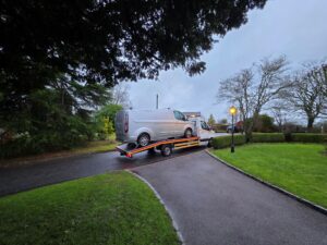 Professional local van recovery Richmond service transporting a silver Ford Transit Custom on a flatbed tow truck.