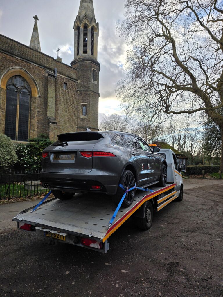 car recovery Twickenham Jaguar F-Pace secured on flatbed tow truck