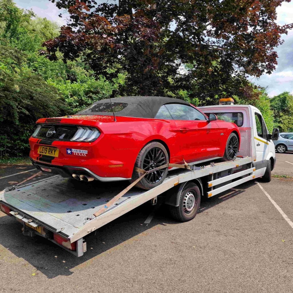 Breakdown recovery Kingston red Ford Mustang on flatbed recovery truck.
