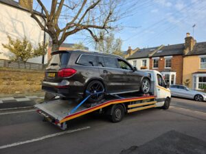 Professional insured impound car recovery of a bronze Mercedes GLS SUV from a police compound using a secure flatbed tow truck across the London area.
