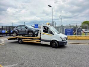 Grey SUV on flatbed truck for professional police compound recovery Kingston at Perivale Vehicle Pound.
