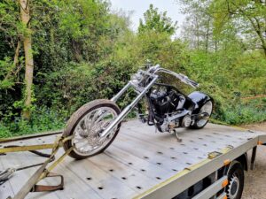 Custom chopper motorcycle secured on a flatbed recovery truck for professional motorbike recovery Kingston upon Thames.