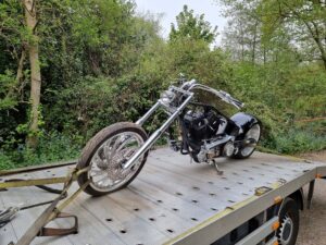Motorbike impound car recovery from police compound in London using flatbed tow truck with secure strapping and specialist handling