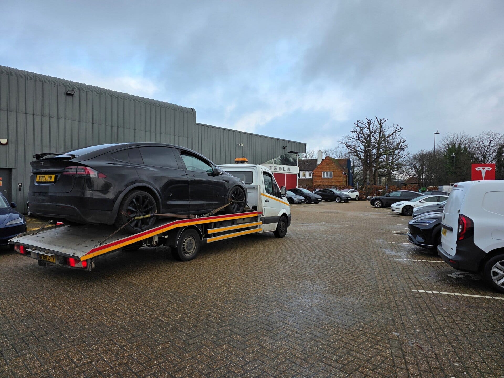 Tesla electric car recovery on flatbed tow truck outside Tesla service centre