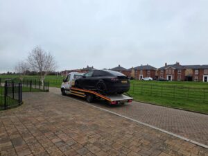 Black Tesla Model X loaded on a flatbed recovery truck for expert electric car recovery Kingston.