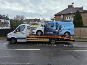 Van recovery Twickenham transporting Volkswagen Caddy commercial van on flatbed tow truck