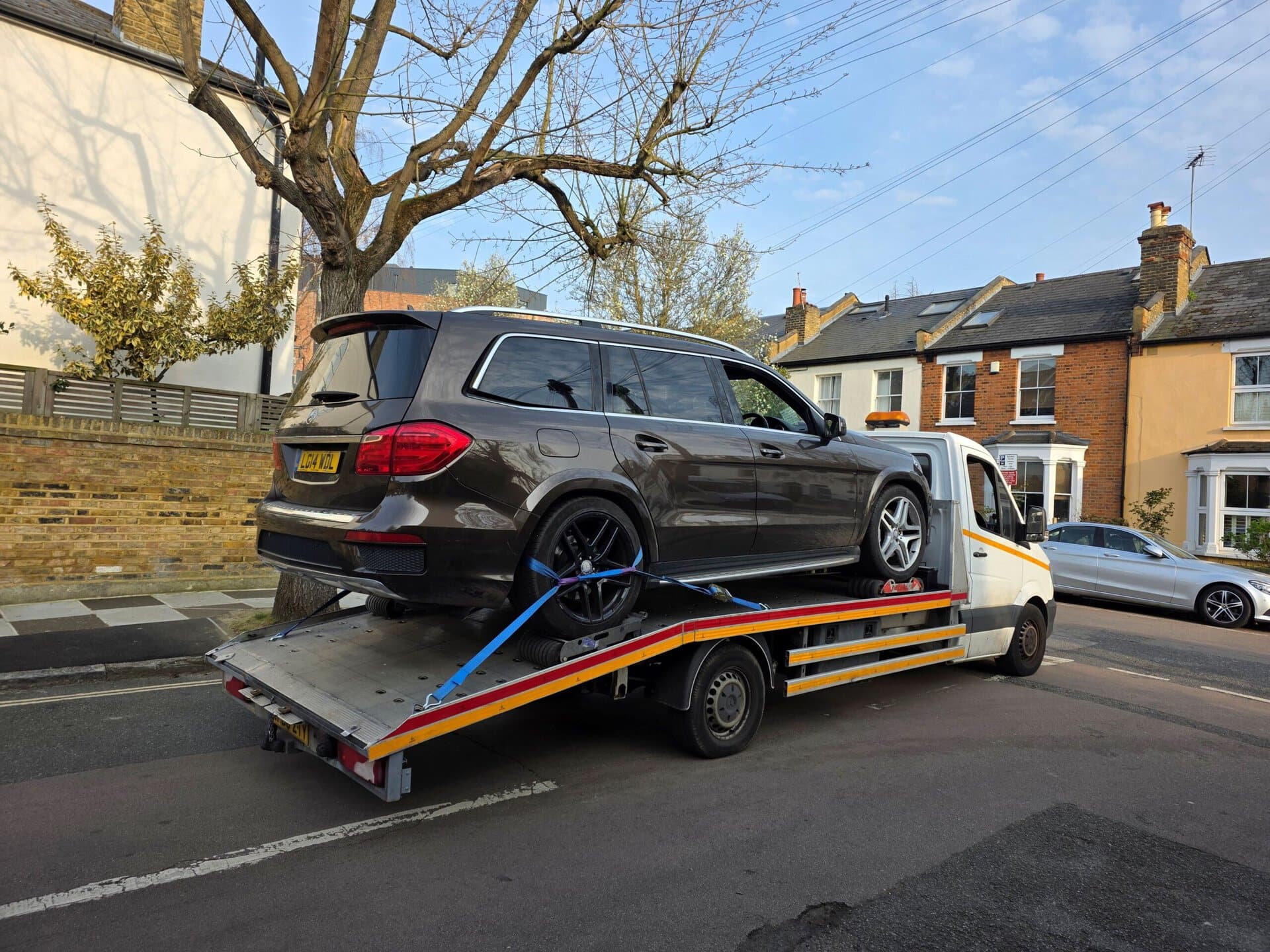 Mercedes-Benz GL SUV safely loaded on a flatbed tow truck for professional car recovery Fulham and breakdown recovery in SW6 area.