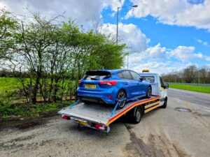 Blue Ford Focus ST Line on a flatbed recovery truck for 24/7 breakdown recovery and reliable towing service near Kensington W8.