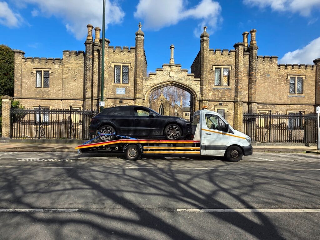 Porsche Macan on a flatbed tow truck for prestige car recovery in Fulham SW6 by an IMI expert vehicle inspector.