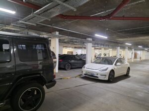 White Tesla Model 3 being towed by a black Mercedes G-Wagon for expert underground car recovery in Kensington London W8.