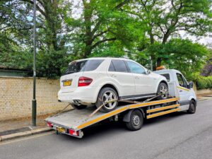 White Mercedes-Benz ML63 AMG on a flatbed truck for our professional we buy any cars Fulham service in the SW6 district.