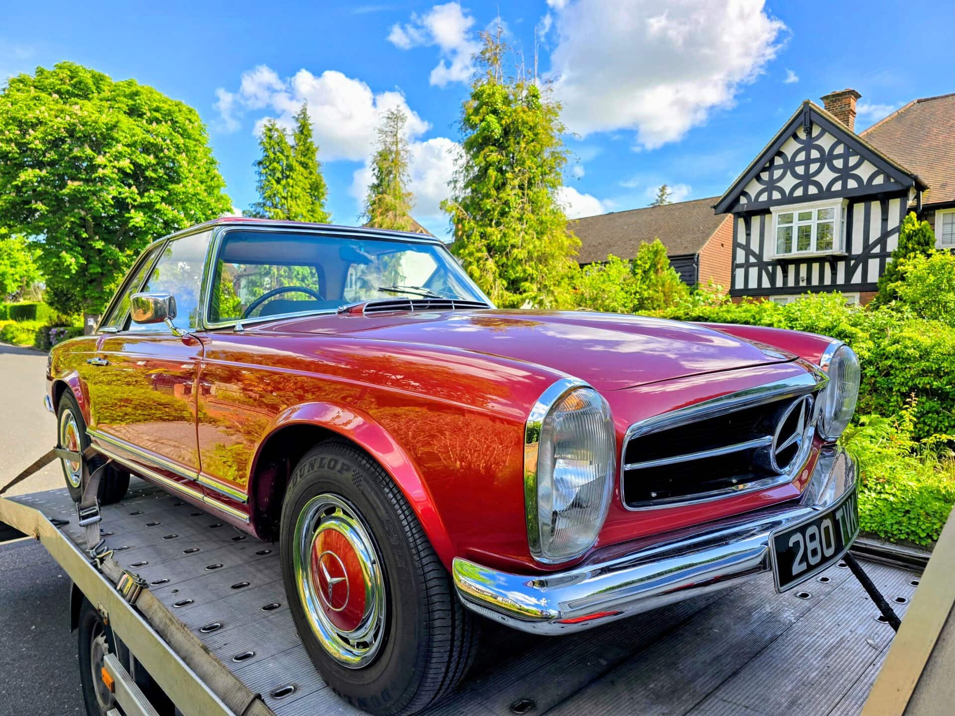 Red Mercedes-Benz 280 SL on a flatbed tow truck during car recovery Kensington W8. One of 13,000+ successful local rescues.