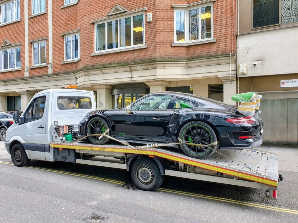 Porsche 911 GT3 RS on a flatbed tow truck after air cargo collection for performance car recovery in Kensington.