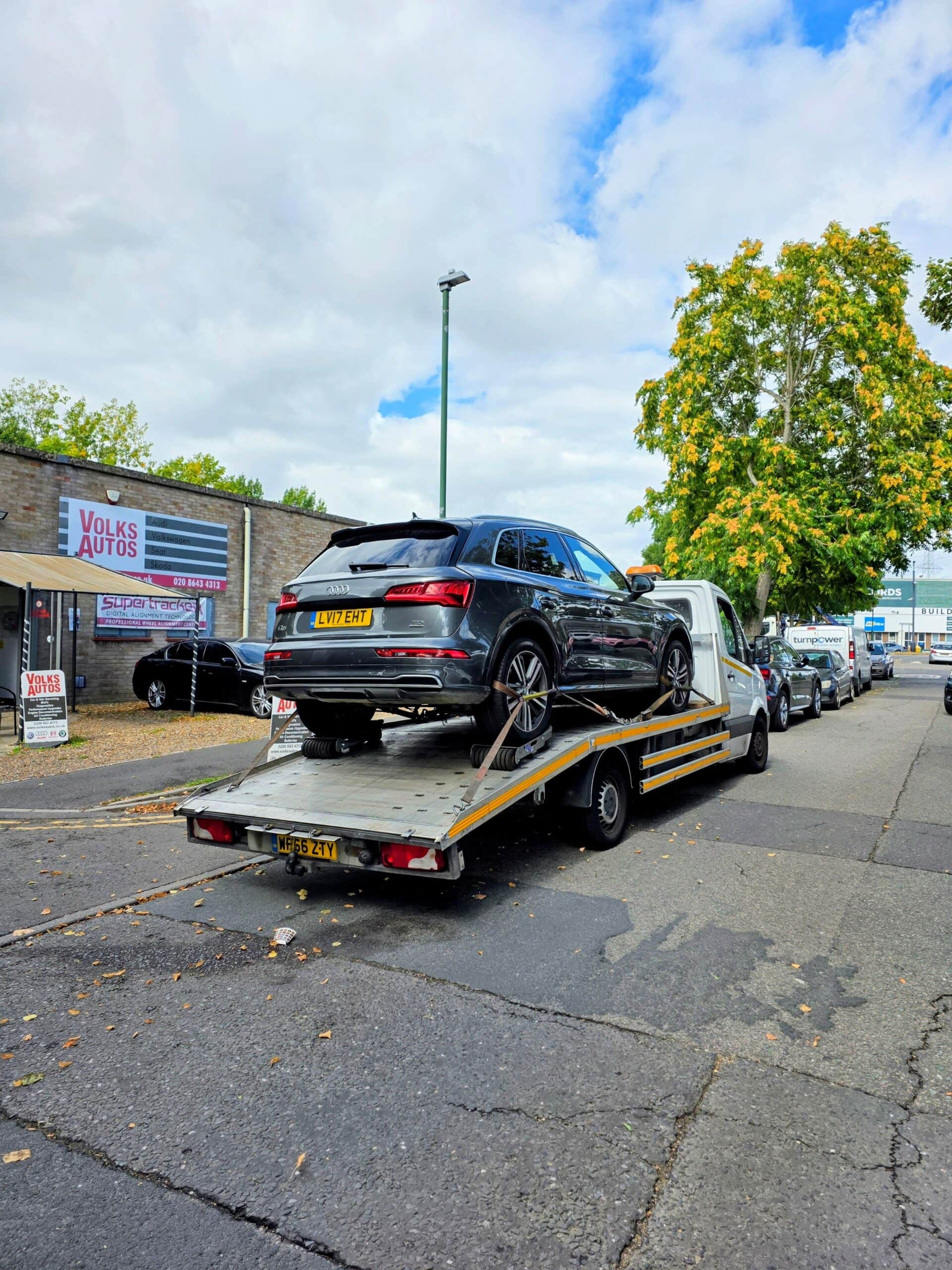 Audi Q5 with wheel skates on a flatbed recovery truck for professional car recovery Kensington in West London.