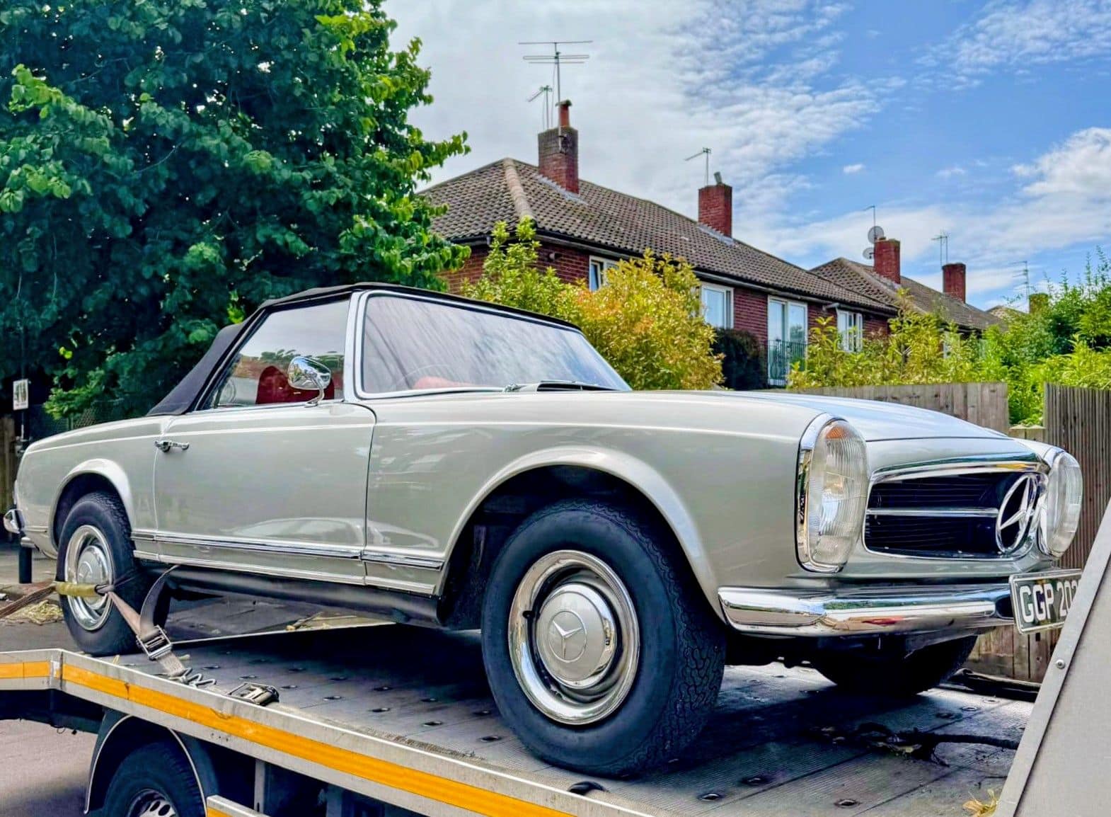 Classic Mercedes Benz SL Pagoda car recovery Kensington on flatbed tow truck residential street.