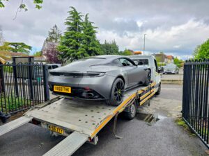 Grey Aston Martin DB11 secured on a flatbed tow truck during high performance luxury car recovery in Chiswick W4.